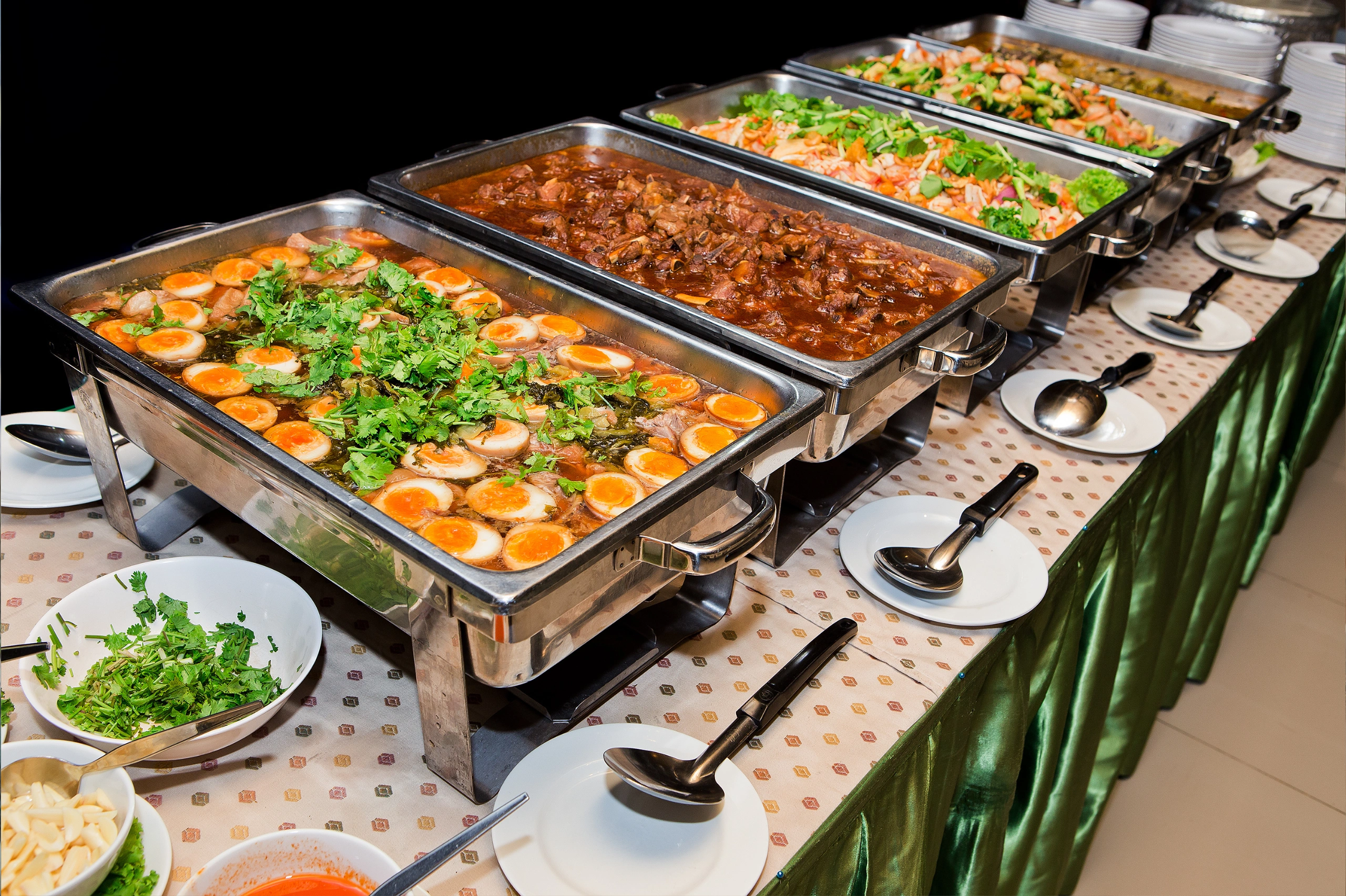Assortment of dishes displayed on a buffet table, featuring a variety of Thai and international cuisines.
